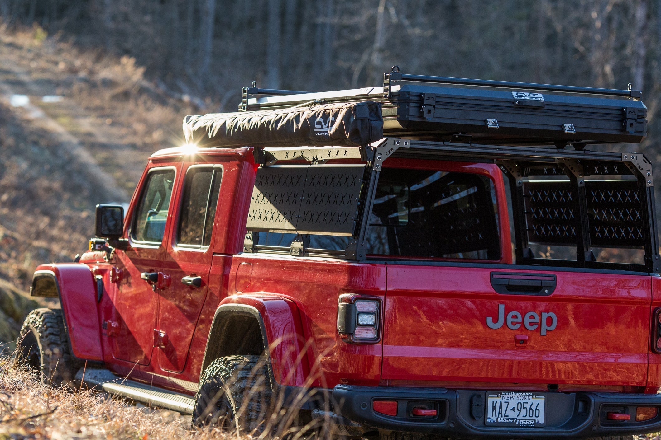 KB Voodoo CXR Fortress overland bed rack with rooftop tent mounted on red Jeep Gladiator on off-road trail