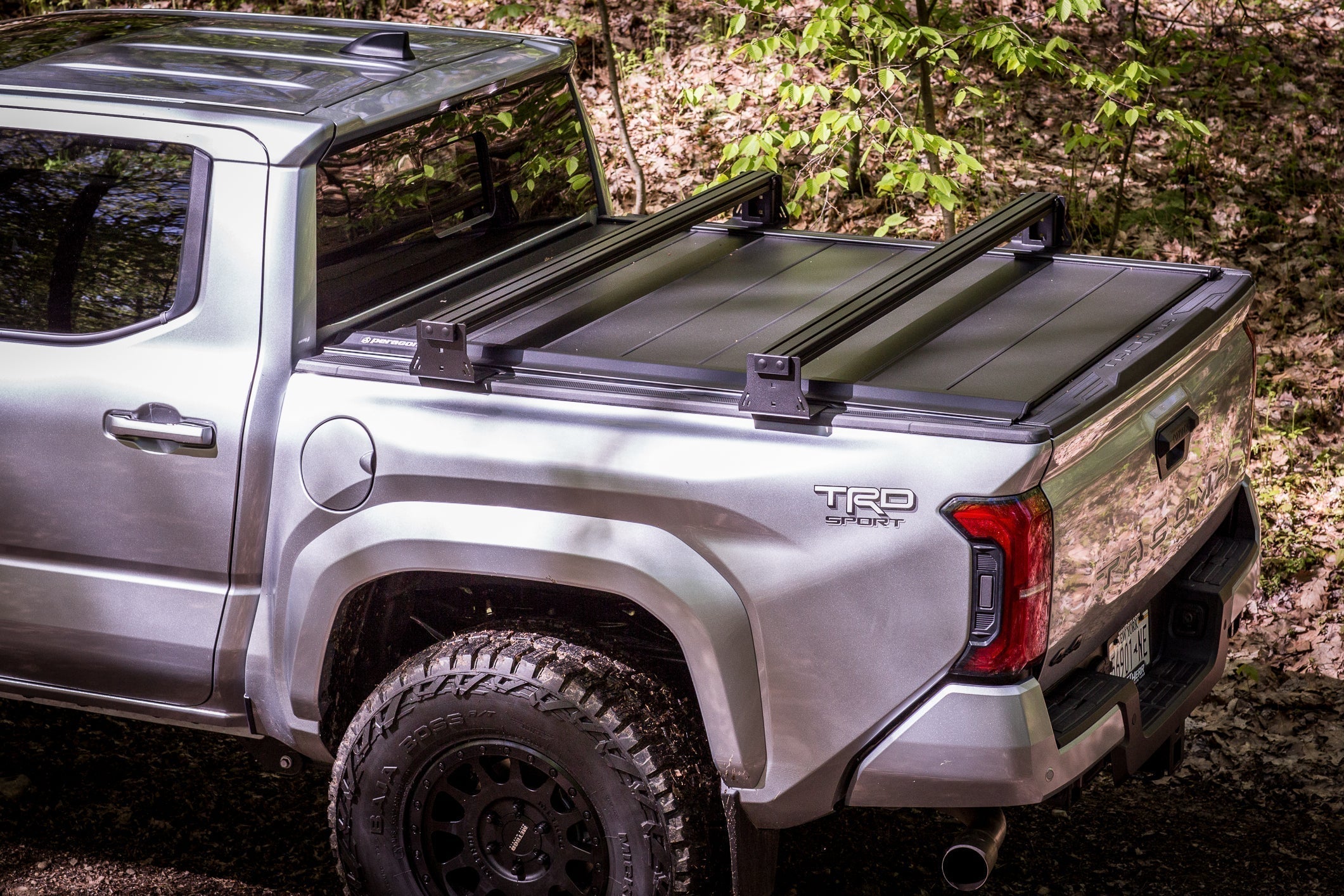 KB Voodoo CXR tonneau compatible truck bed crossbar system on silver Toyota Tacoma TRD Sport with Peragon tonneau cover