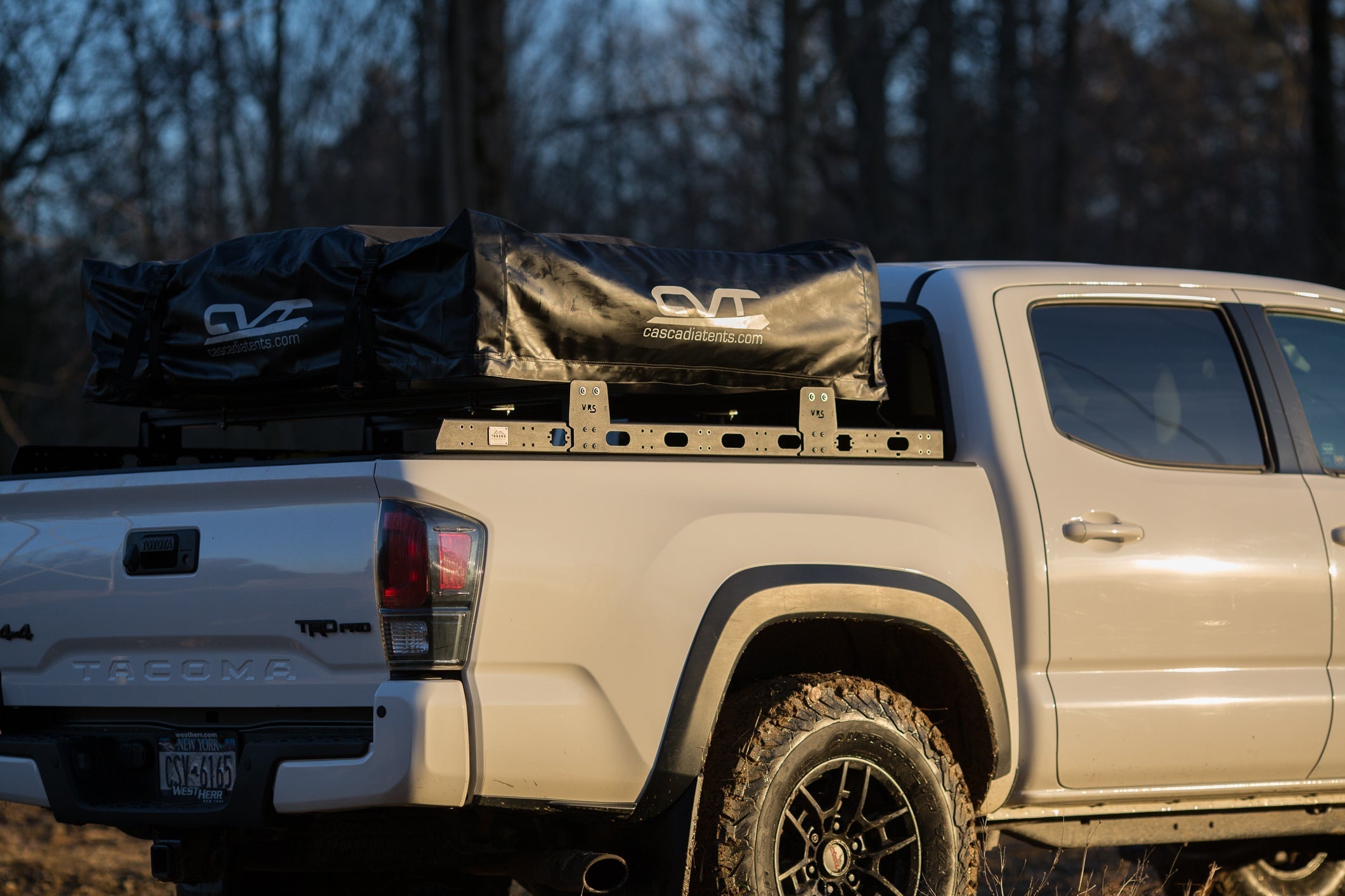 Toyota Tacoma TRD Pro with a KB Voodoo VRS bed rack and rooftop tent mounted, shot at golden hour