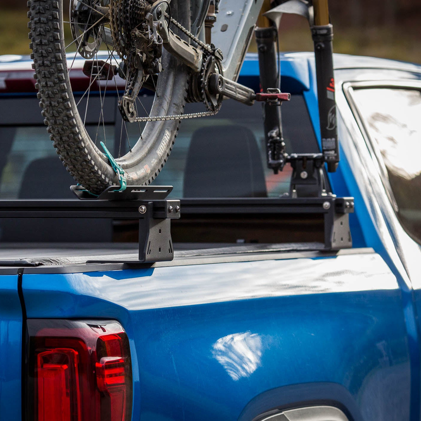 Blue truck with a bicycle mounted on a roof rack